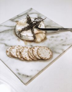 baked brie, rosemary sprigs, water crackers, silver knife, marble cheese plate